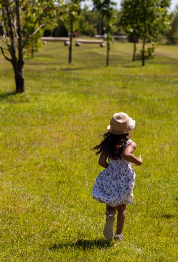 Ребенок в шляпе бежит по траве. Фото Свободно для коммерческого использования, Атрибуция не требуется. Бесплатное стоковое фото для свободного скачивания