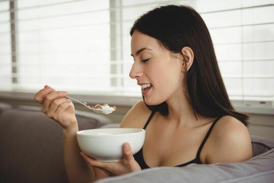 Улыбающаяся женщина завтракает. Фото Свободно для коммерческого использования, Атрибуция не требуется. Бесплатное стоковое фото для свободного скачивания